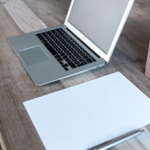 54m 聚合导航说明文案编辑的工作场景：笔记本屏幕上是一段正在修改的目录说明文字，旁边放着一杯凉掉的茶，灯光偏暖，氛围安静